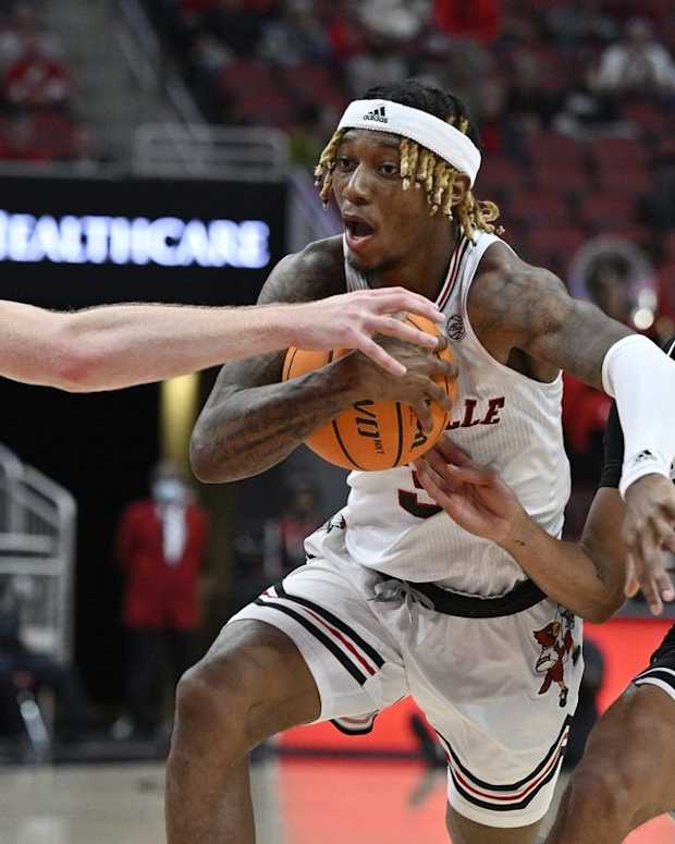 Nov 12, 2022; Louisville, Kentucky, USA; Louisville Cardinals guard El Ellis (3) drives to the basket under the pressure of Wright State Raiders forward Brandon Noel (14) and guard Trey Calvin (1) during the second half at KFC Yum! Center. Wright State defeated Louisville 73-72. Mandatory Credit: Jamie Rhodes-USA TODAY Sports